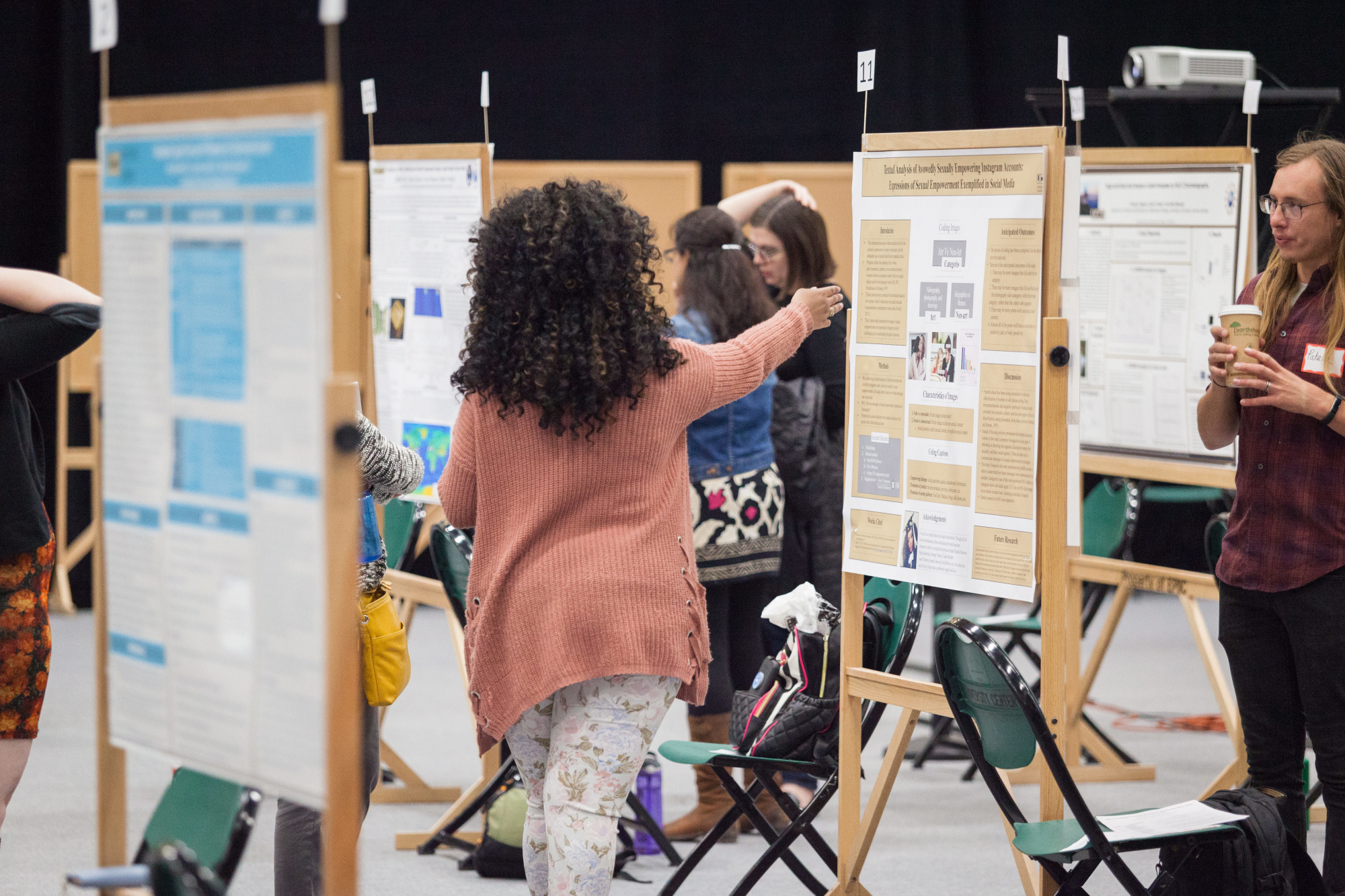 A group of people standing around bulletin boards.