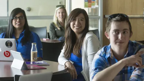 Student at a table smiling 