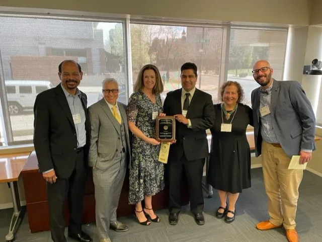 Group of faculties standing around DEI award recipient