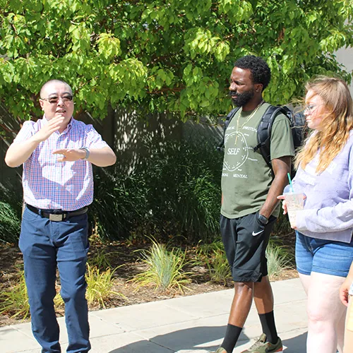 A teacher has a discussion with students outside