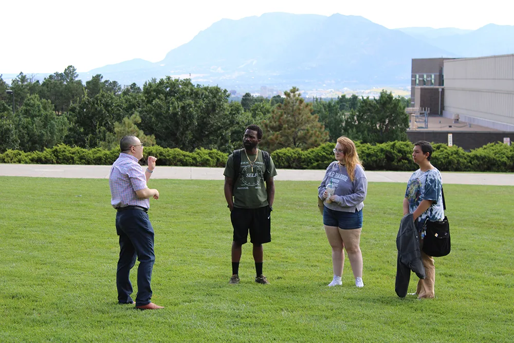 A teacher having a discussion with students outside